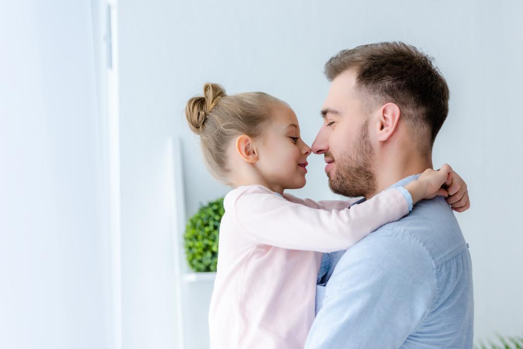 Pai e criança menina abraçando e tocando narizes
 - Foto, Imagem