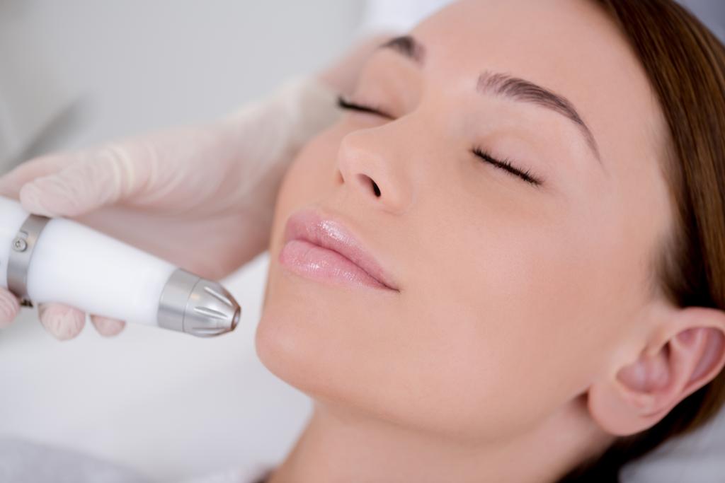 visão parcial da mulher recebendo tratamento facial no salão de cosmetologia
 - Foto, Imagem