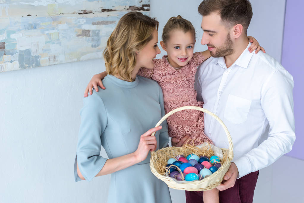 Genitori e figlia con cesto con uova di Pasqua
 - Foto, immagini