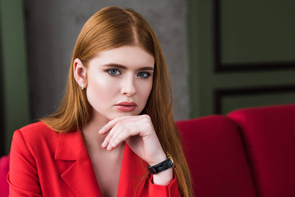 Aantrekkelijke stijlvolle jongedame met horloge poseren in rode jas - Foto, afbeelding