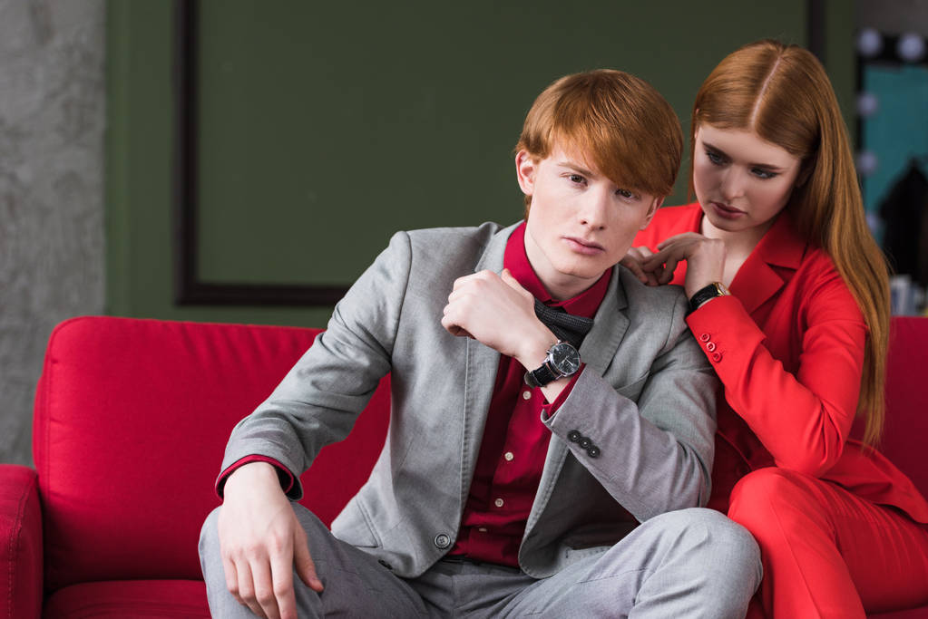 Молодой мужчина модель с девушкой, сидящей на диване
 - Фото, изображение