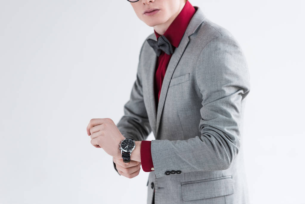Vista recortada de modelo de moda masculina en traje ajustando reloj de pulsera
  - Foto, imagen