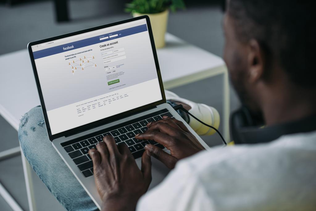 Afrika kökenli Amerikalı gencin ekran Web sitesi facebook ile dizüstü bilgisayar kullanarak atış kırpılmış - Fotoğraf, Görsel