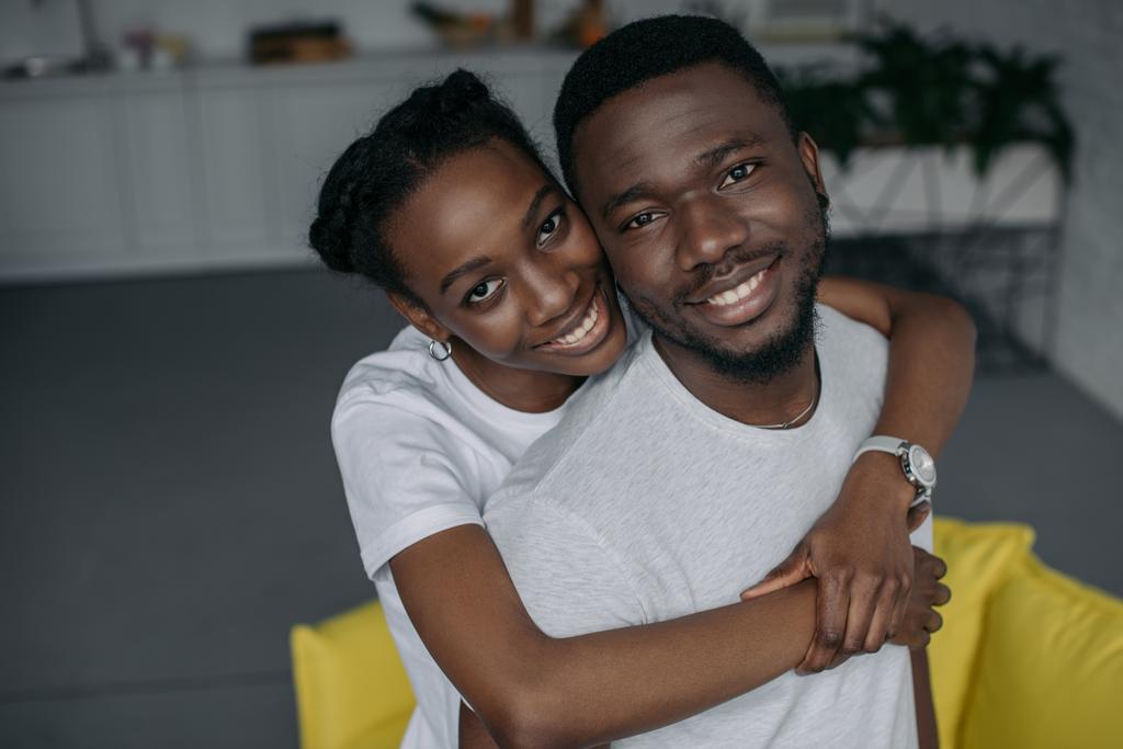 felice giovane coppia afro-americana abbracciare e sorridere alla macchina fotografica
 - Foto, immagini