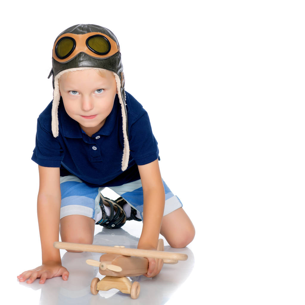 Niño pequeño con un avión de madera
. - Foto, imagen