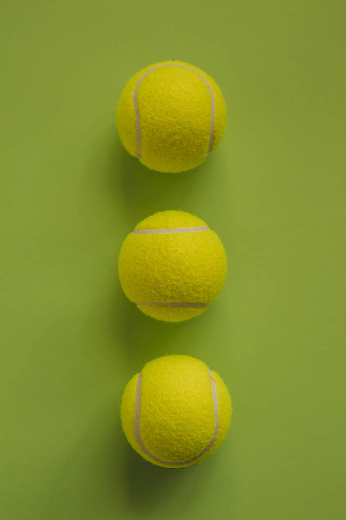 Три теннисных мяча на зеленом фоне
. - Фото, изображение