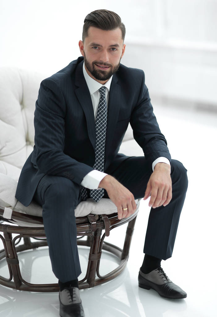 Selbstbewusster Geschäftsmann sitzt auf einem Stuhl - Foto, Bild