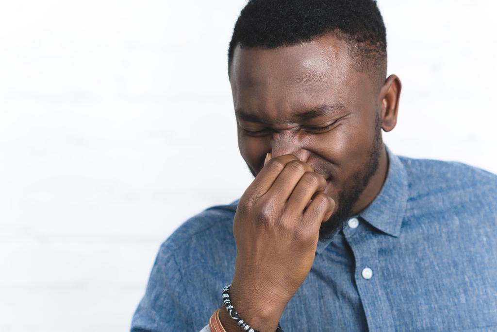 Giovane africano americano uomo toccare il naso
 - Foto, immagini