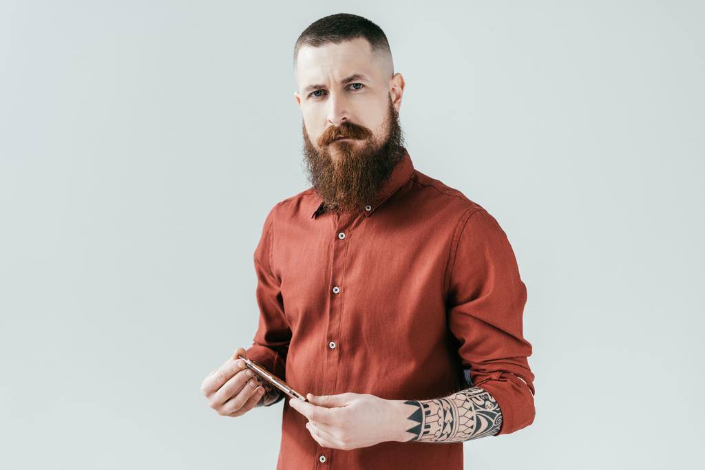 bearded handsome barber holding razor and looking at camera isolated on white - Photo, Image