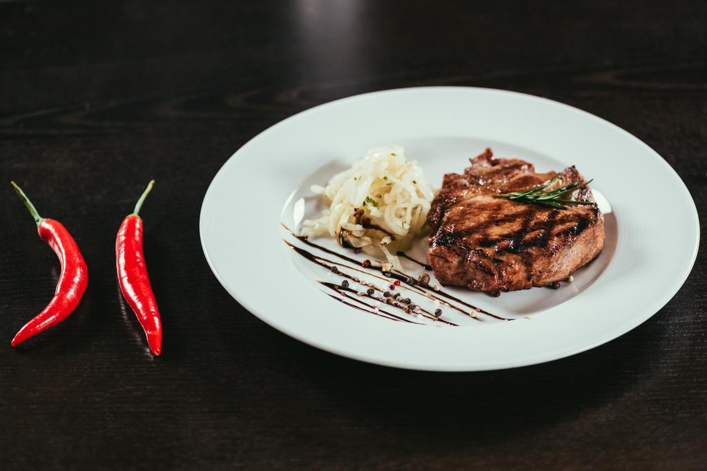 delicious grilled juicy steak with rosemary and chilli peppers on table - Photo, Image