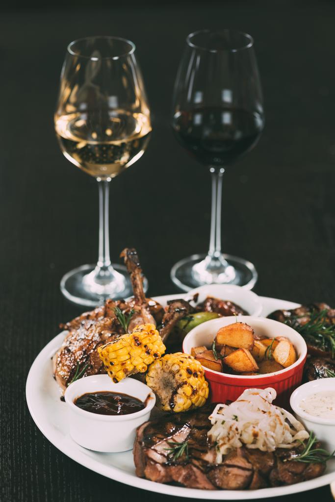 copos de vinho e prato com legumes grelhados gourmet e carne na mesa no restaurante
  - Foto, Imagem