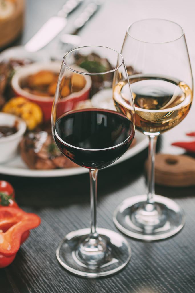 テーブルにワインと肉とグリル野菜プレートのメガネのクローズ アップ ビュー - 写真・画像