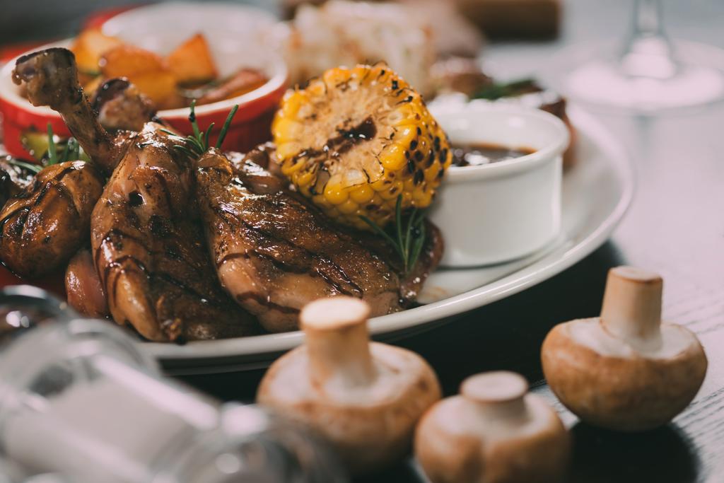 vista close-up de delicioso frango grelhado com milho, cogumelos e molho na mesa
 - Foto, Imagem