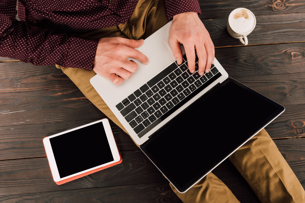 Impressão de empresário em laptop com tela em branco, tablet digital e xícara de café ao lado
 - Foto, Imagem