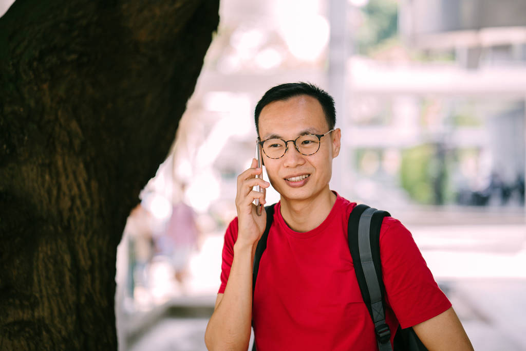hombre asiático de mediana edad con teléfono en la ciudad
 - Foto, imagen