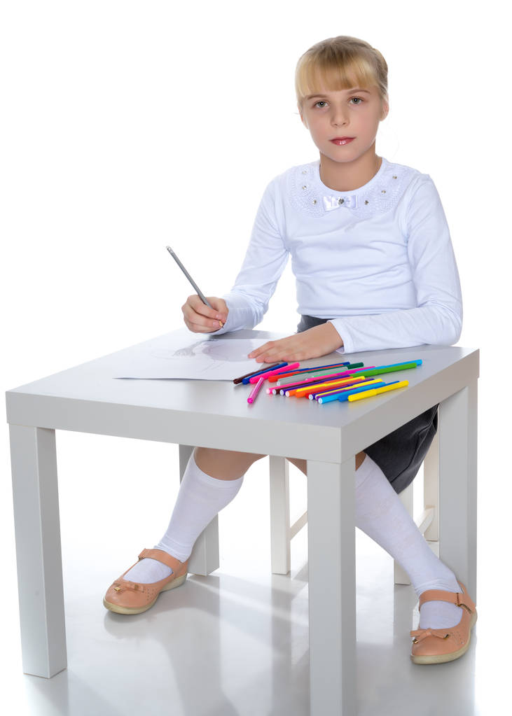 Una niña está dibujando en la mesa.
. - Foto, Imagen