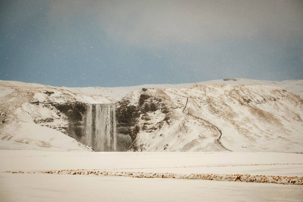 Skogafoss, a nagy és gyönyörű vízesés, Izland télen. A hó hófúvás Izland közelében a híres Skogafoss-vízesés. - Fotó, kép