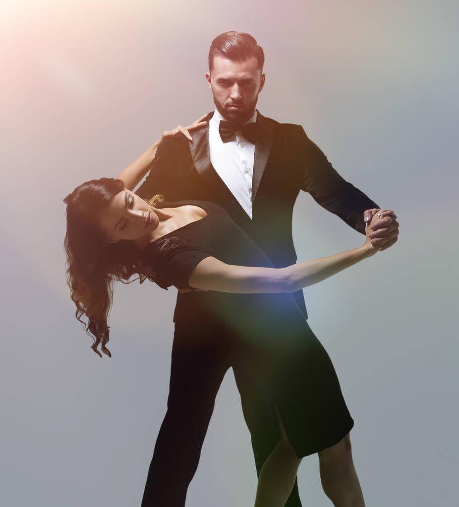 Портрет молодой пары, танцующей на сером фоне
 - Фото, изображение