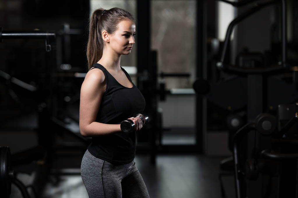 Fitness nainen tekee liikuntaa Biceps kanssa käsipainot
 - Valokuva, kuva