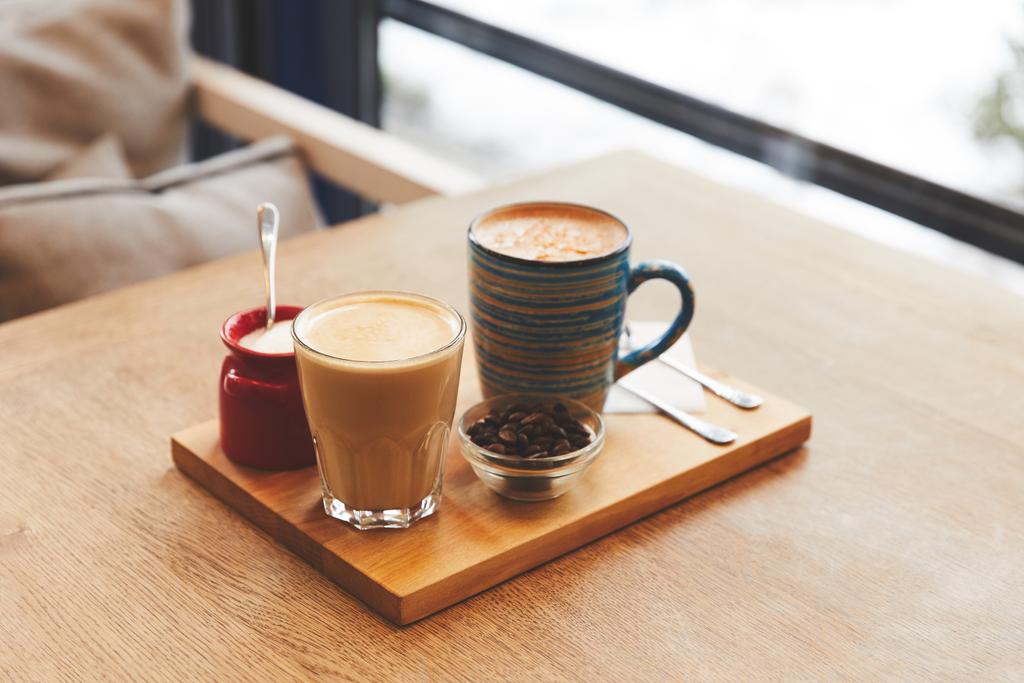 Ροφήματα καφέ με φασόλια και Πορτοκάλι φλούδα στο τραπέζι στην καφετέρια - Φωτογραφία, εικόνα