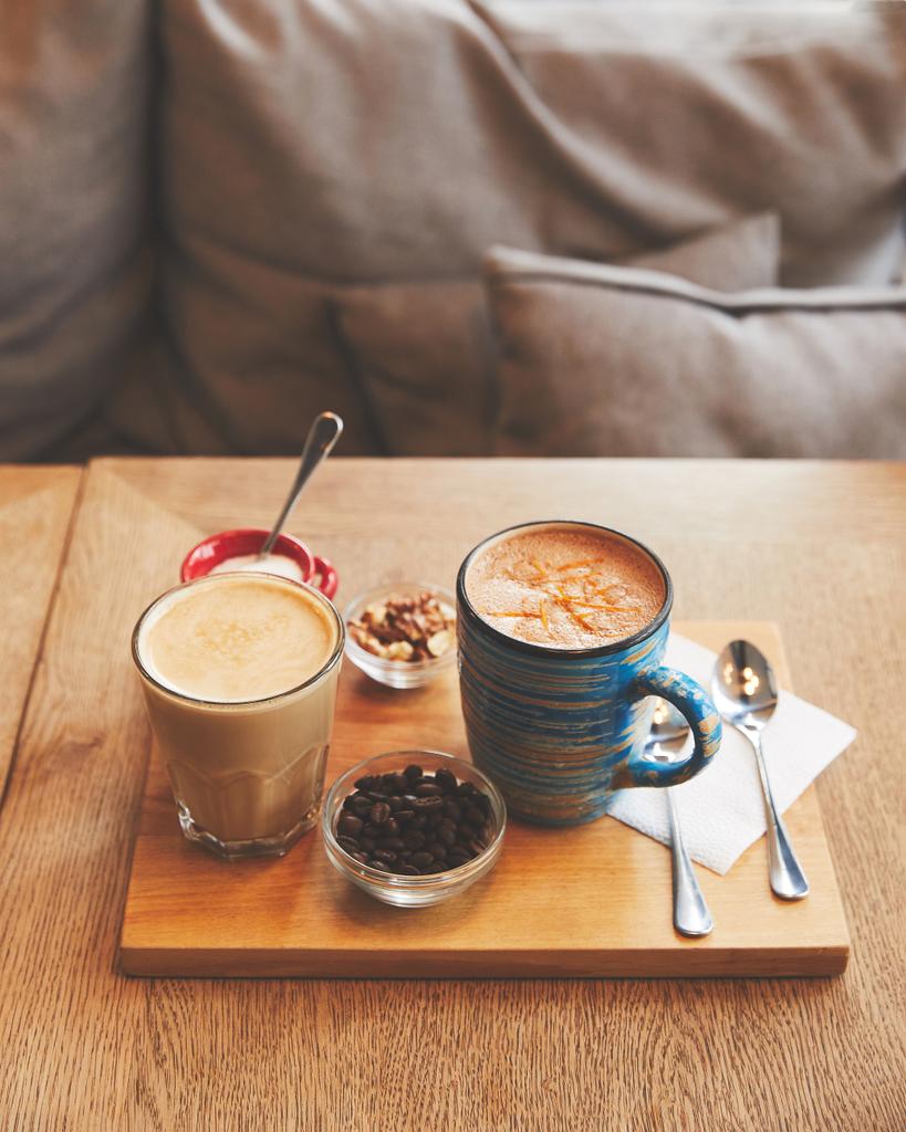 Bebidas calientes de café en vaso y taza con frijoles y nueces
 - Foto, imagen