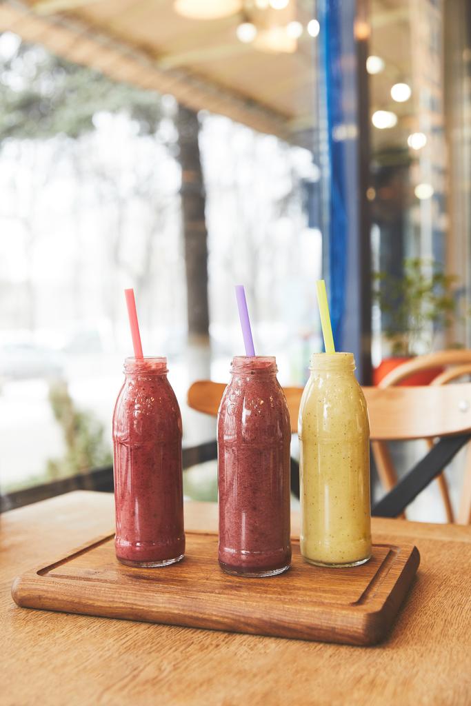 Bottles with assorted smoothies on wooden table - Photo, Image