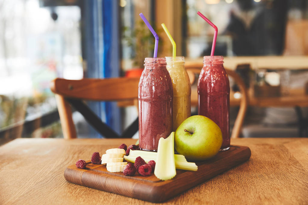 Ovoce a smoothie v lahvích na stůl v kavárně - Fotografie, Obrázek