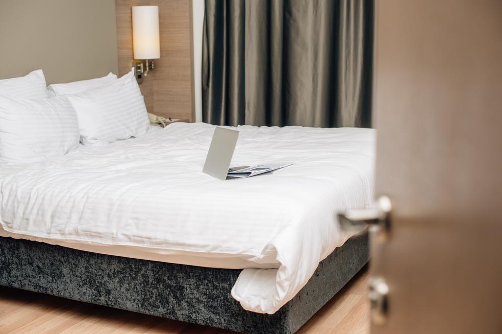 ноутбук на кровати в современном номере отеля
 - Фото, изображение