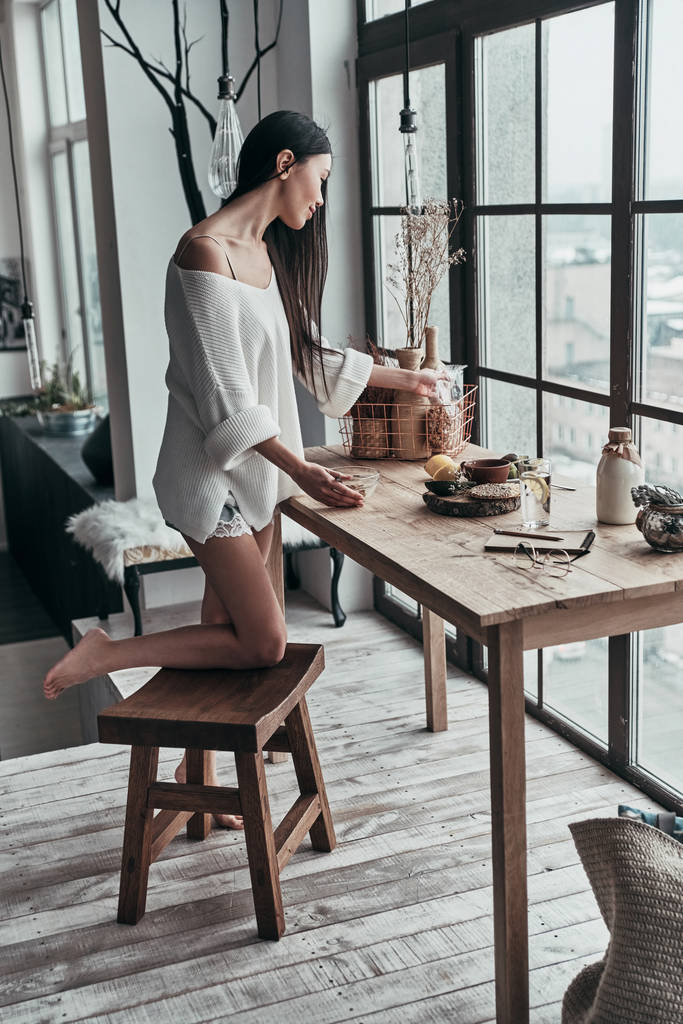 comprimento total de morena jovem cozinhando café da manhã saudável na mesa de madeira
  - Foto, Imagem