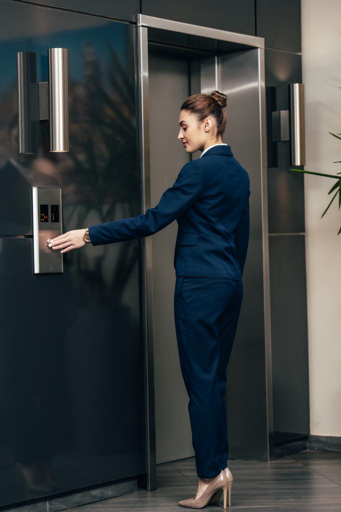 jeune femme d'affaires attrayante appuyant sur le bouton de l'ascenseur
 - Photo, image
