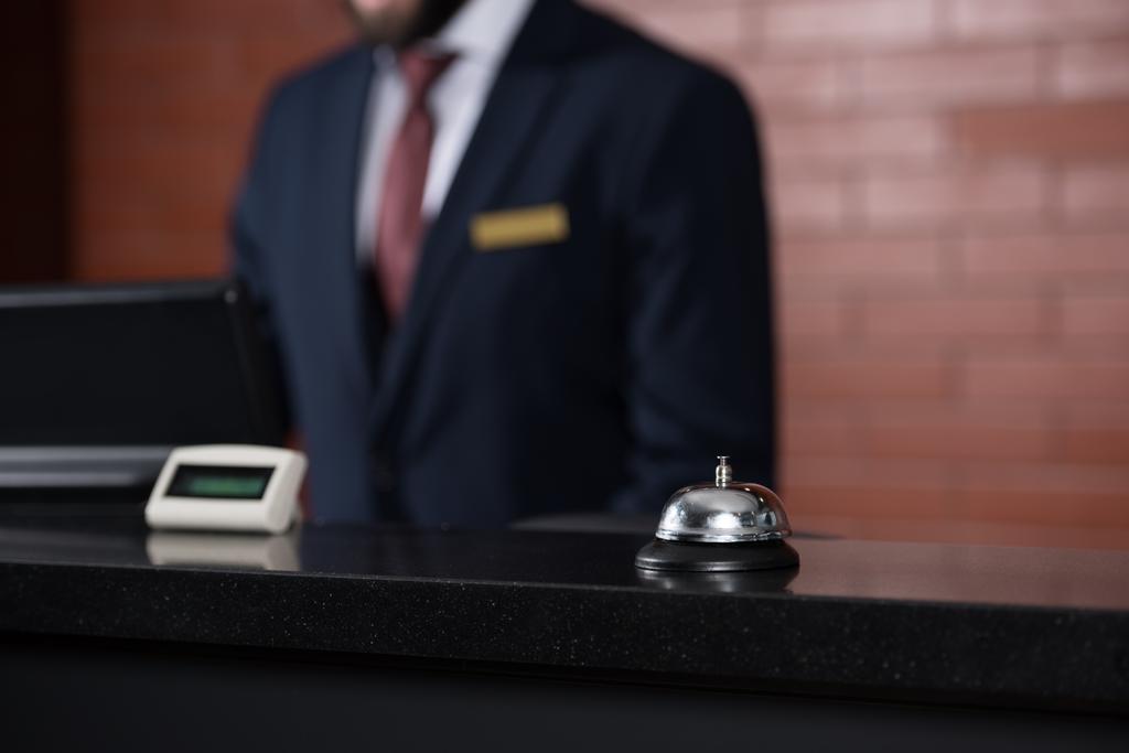 hotel reception desk with bell and blurred receptionist on background - Photo, Image