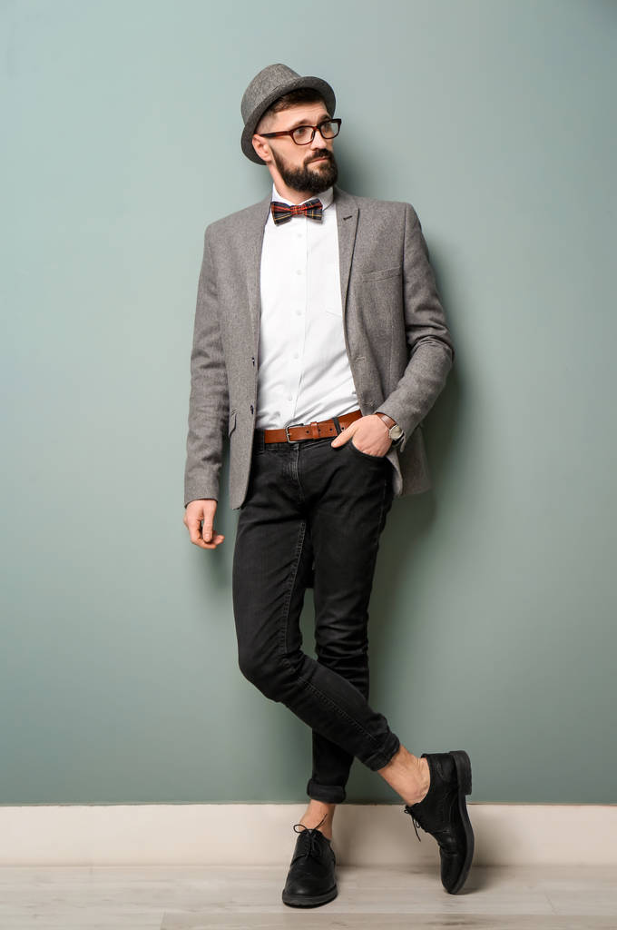Retrato de hipster bonito na roupa elegante perto da parede de cor
 - Foto, Imagem