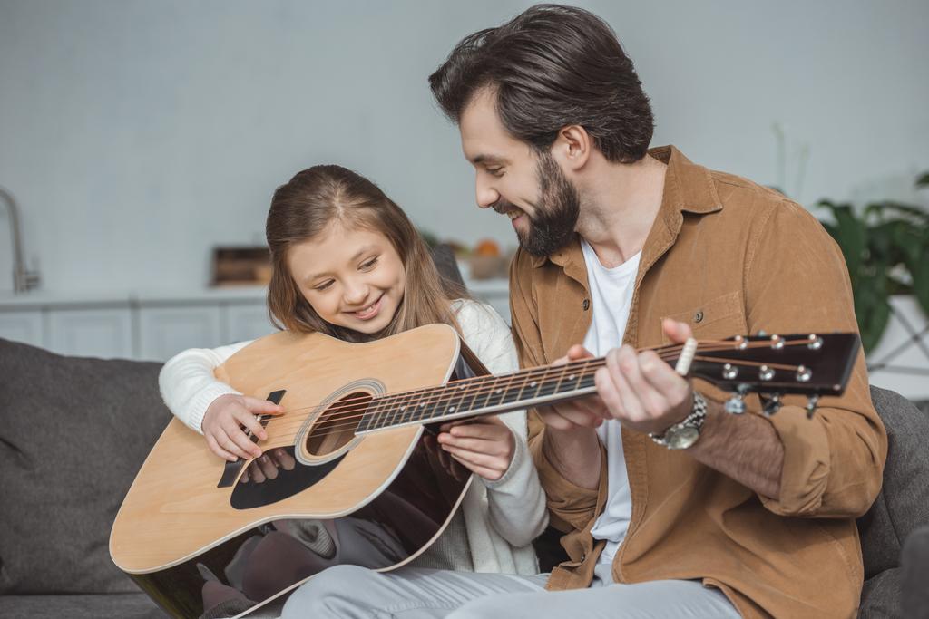 Šťastný otec výuka dcera hraje na akustickou kytaru - Fotografie, Obrázek