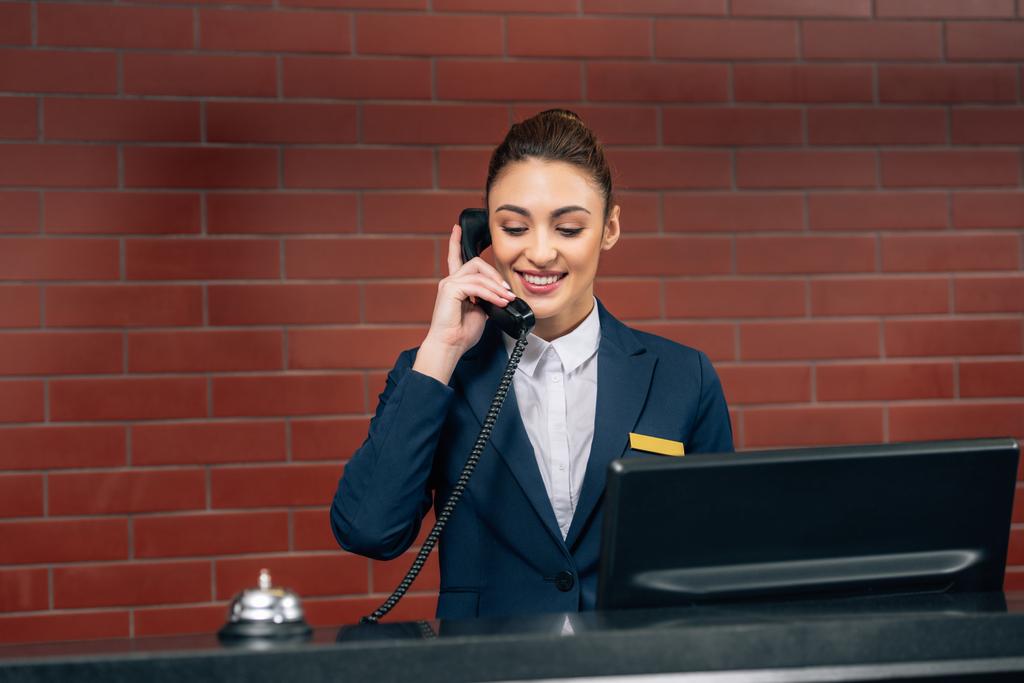 jovem recepcionista bonito hotel recebendo chamada no local de trabalho
 - Foto, Imagem