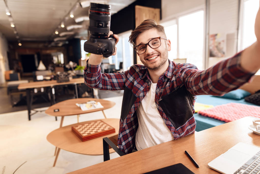 Freelancer hombre tomando selfie en portátil sentado en el escritorio
. - Foto, imagen