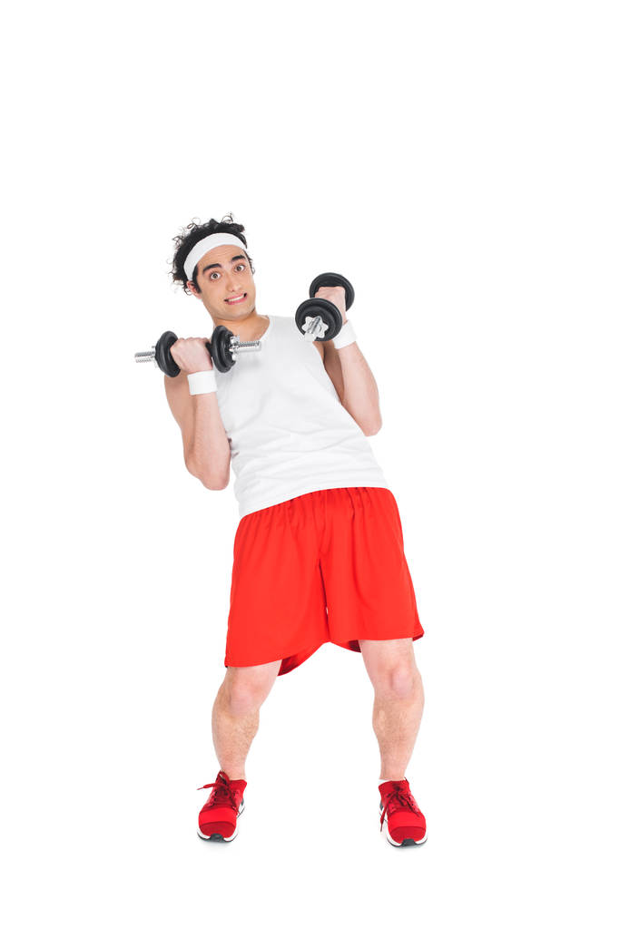 Thin man in headband exercising with dumbbells isolated on white - Photo, Image