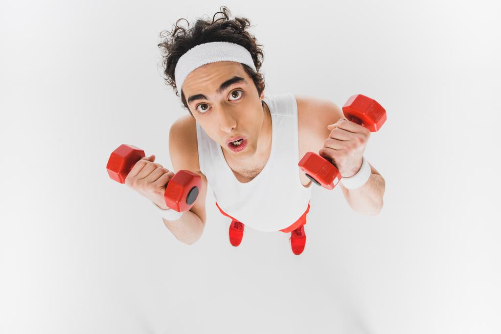 Hochwinkelaufnahme eines dünnen Sportlers mit auf Weiß isolierten Kurzhanteln - Foto, Bild