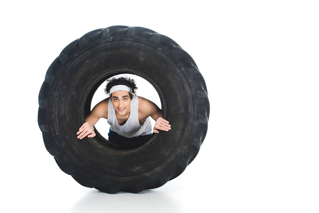 Tenké sportovec s čelenkou uvnitř pneumatiky kola izolované na bílém - Fotografie, Obrázek