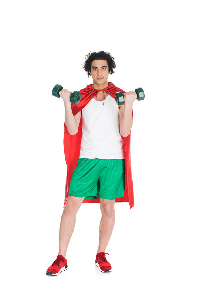 Thin sportsman with dumbbells in hands and wearing red cape isolated on white - Photo, Image