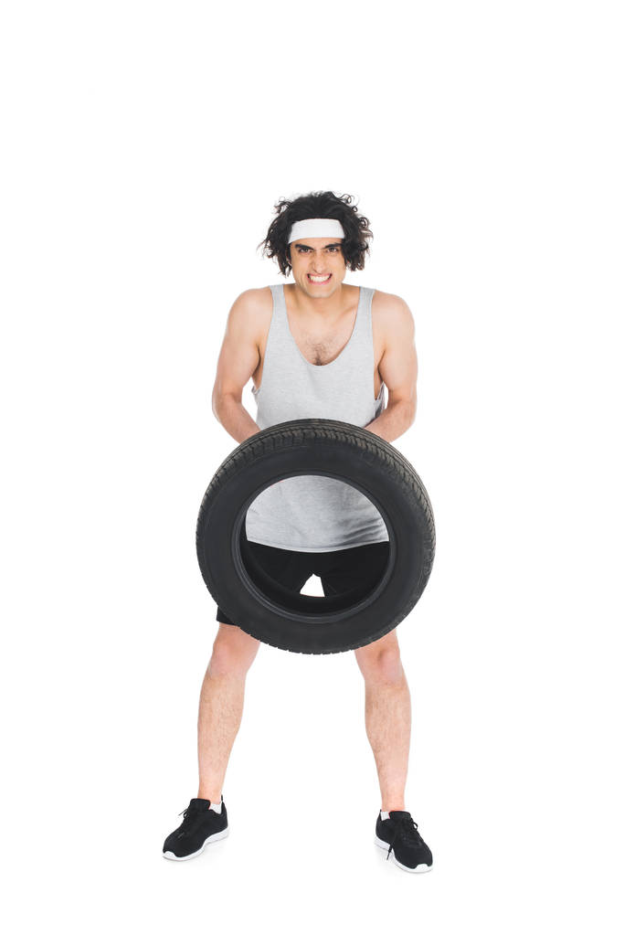 Dünner Sportler mit Reifen in der Hand isoliert auf weißem Untergrund - Foto, Bild