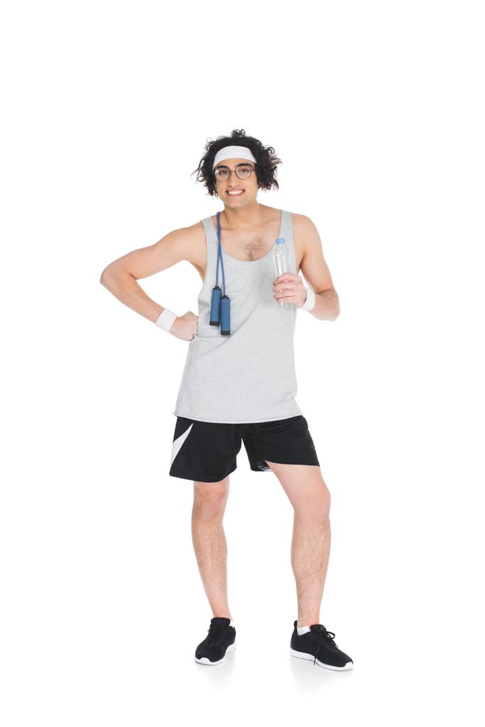 Sonriente deportista delgado de pie con cuerda de salto en el hombro aislado en blanco
 - Foto, imagen