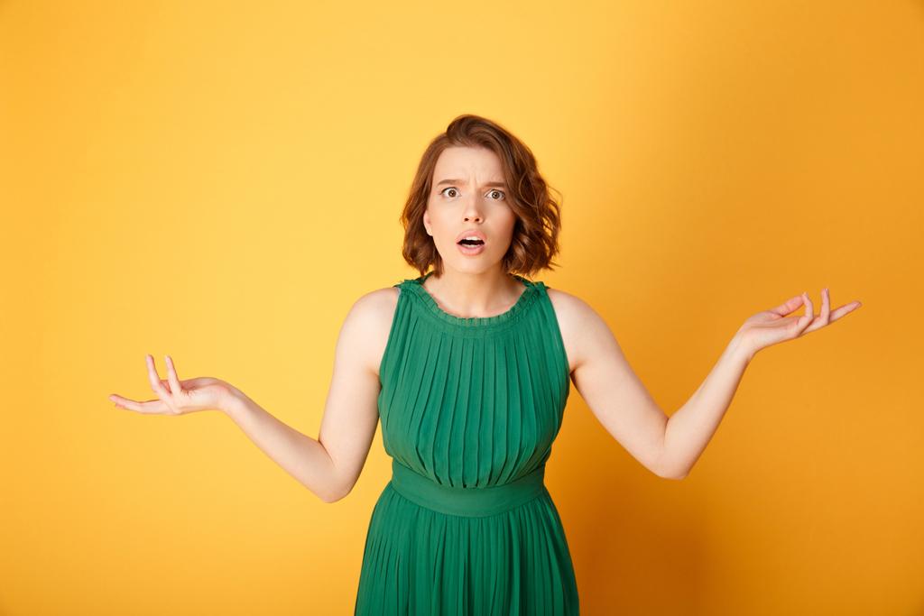 πορτρέτο του σοκαρισμένος γυναίκα με τα χέρια απλωμένα απομονώνονται σε πορτοκαλί - Φωτογραφία, εικόνα