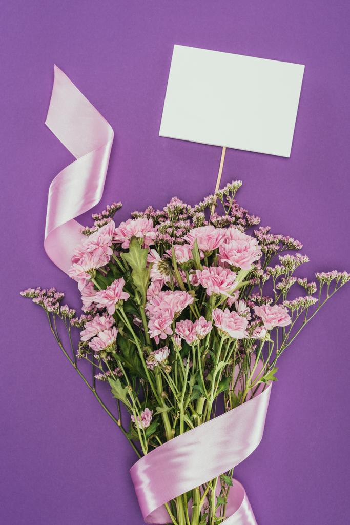 bouquet di bellissimi fiori rosa con nastro e carta bianca su viola
 - Foto, immagini