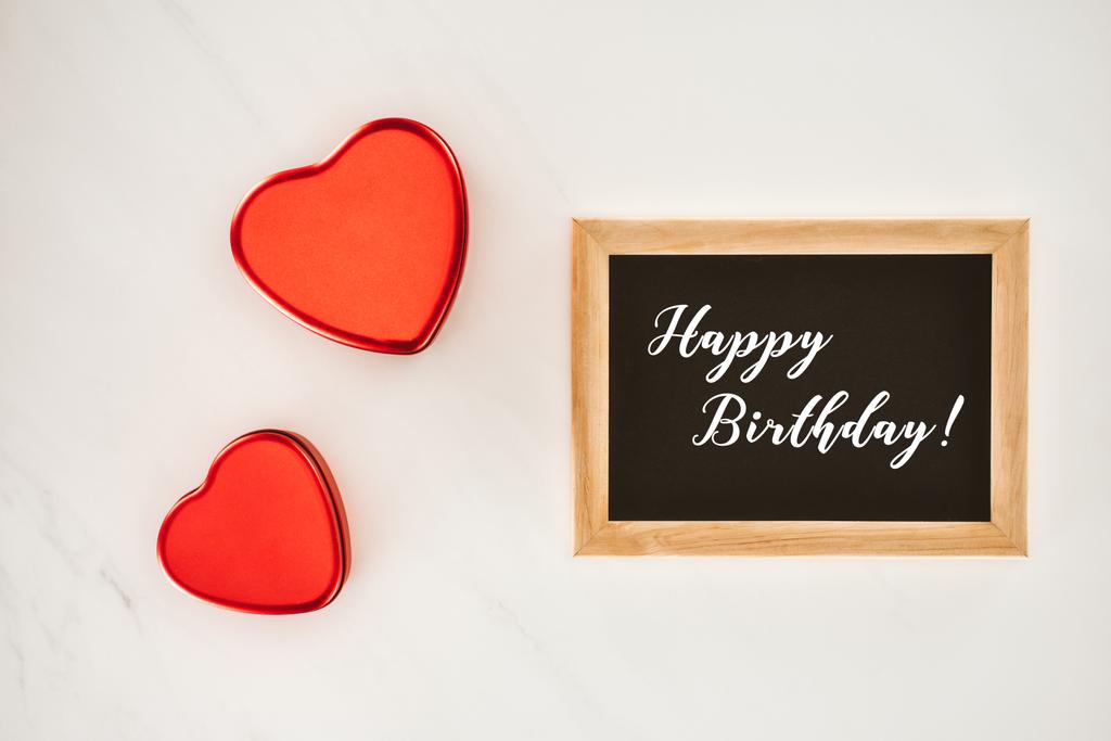 top view of blackboard in frame with HAPPY BIRTHDAY lettering with heart shaped isolated on white - Photo, Image