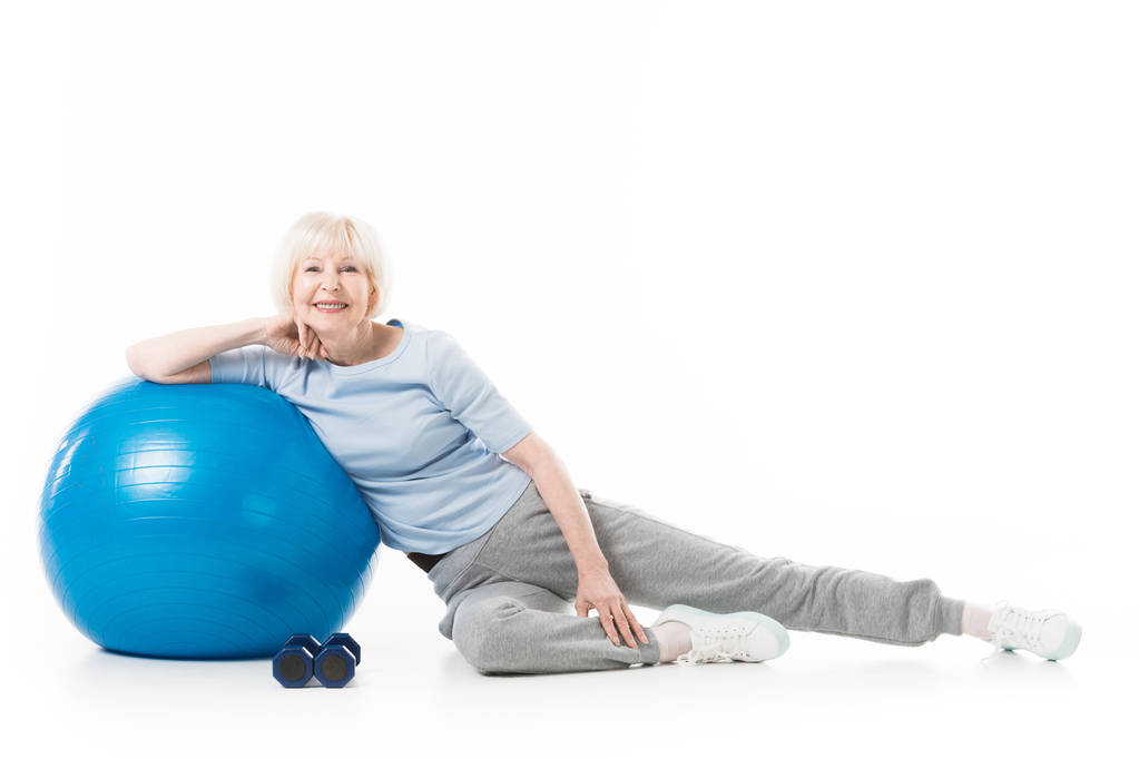 Senior sportswoman with fitness ball and dumbbells isolated on white - Photo, Image