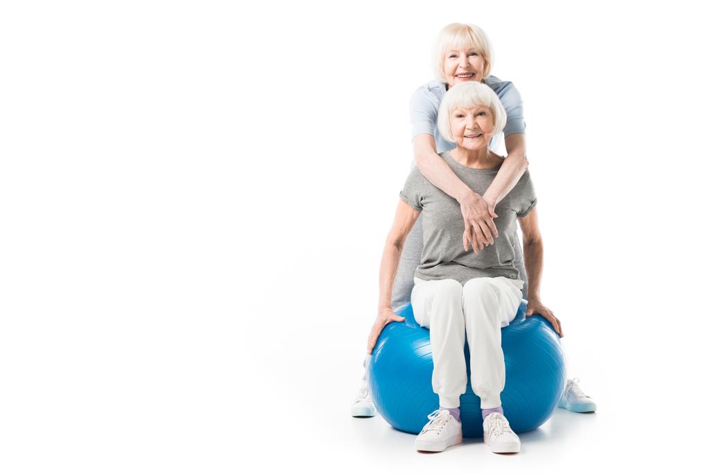 Lächelnde Seniorinnen mit Fitnessball auf weißem Grund - Foto, Bild