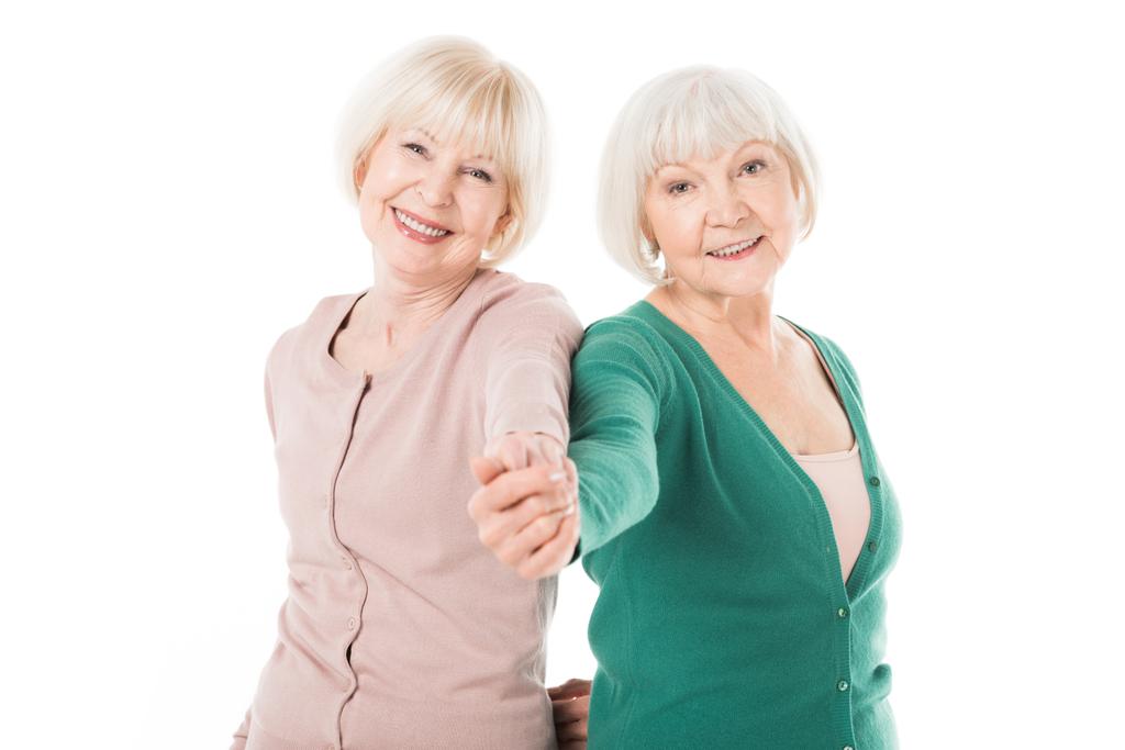 Sorridente donne anziane eleganti che si tengono per mano isolate su bianco
 - Foto, immagini