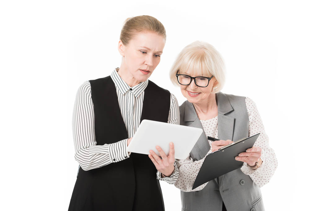 Δύο κομψά επιχειρηματίες με ψηφιακό tablet και πρόχειρο απομονωθεί σε λευκό - Φωτογραφία, εικόνα