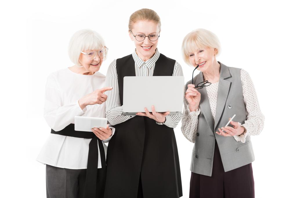 Dizüstü bilgisayar, dijital tablet, smartphone ve üzerinde beyaz izole gözlük ile üç şık iş kadınları - Fotoğraf, Görsel