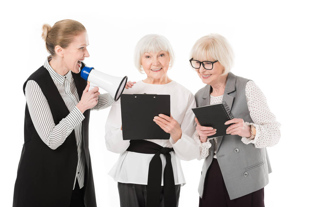 Mulher de negócios madura com megafone e duas empresárias seniores com área de transferência e livro didático isolado em branco
 - Foto, Imagem